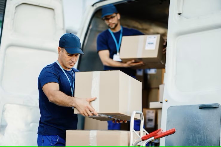 young-courier-his-colleague-unloading-cardboard-boxes-from-delivery-van